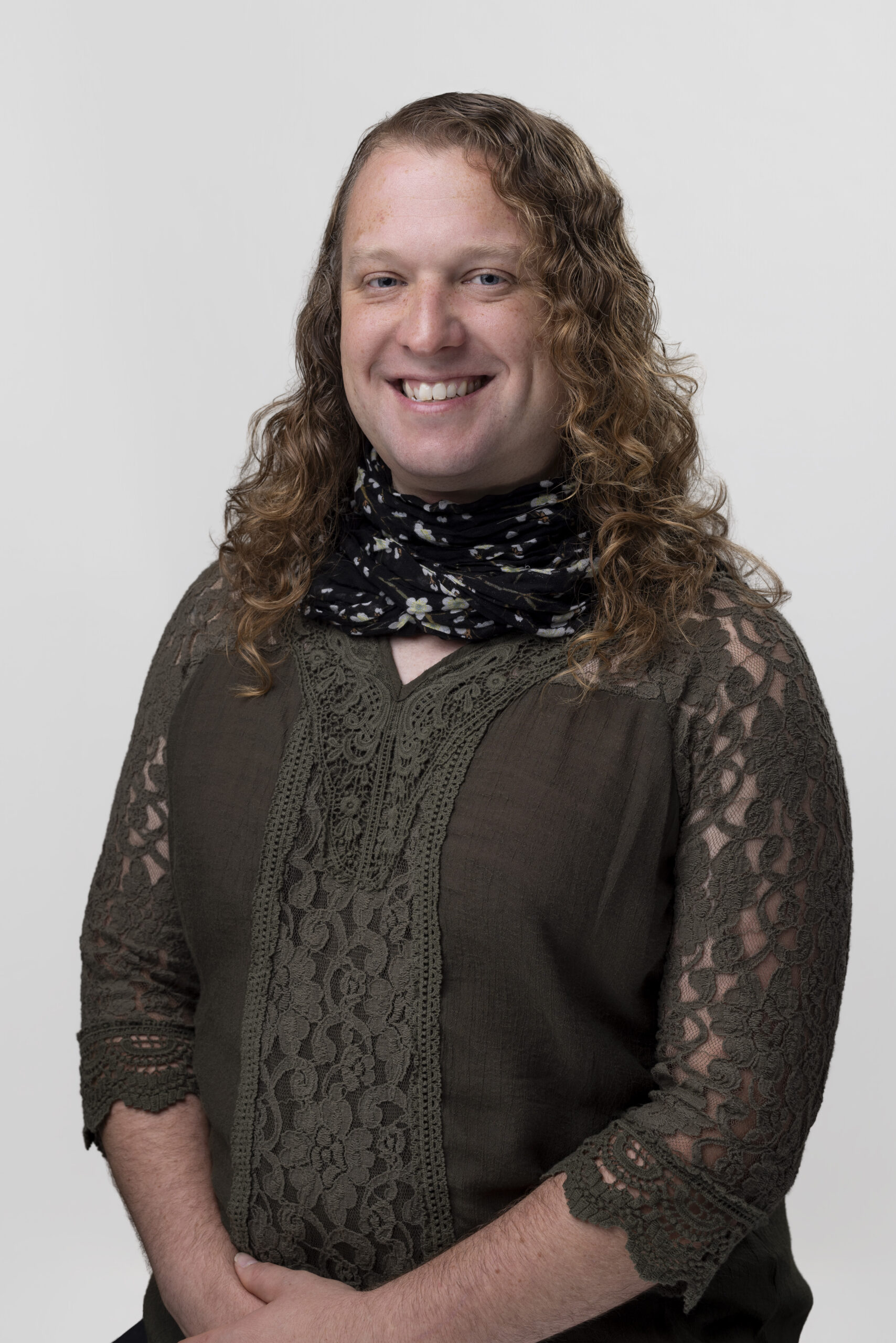 Kay Schachner wearing a green top and scarf, smiling.